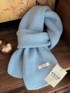 Detailaufnahme eines hellblauen Strickschals aus 100% Wolle mit handgefertigten Etiketten