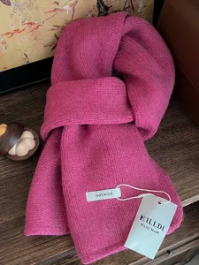 Detailansicht eines rosa gestrickten Schals aus 100 % Wolle mit handgefertigtem Etikett