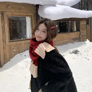 Asian woman wearing a stylish red and beige knit scarf in a snowy winter scene