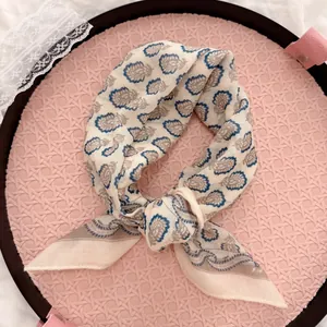 Close-up of an elegant vintage paisley cotton linen square scarf in a rustic floral style