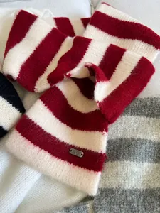 Close-up of red and white striped knitted neck warmer featuring soft wool texture