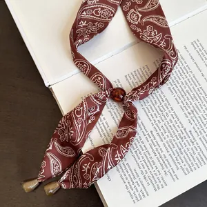 Nahaufnahme einer Vintage Paisley Seidenschalkette mit Bernsteinperlen