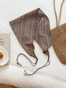 Detailed close-up of a retro striped triangle scarf with elegant beaded tie straps.