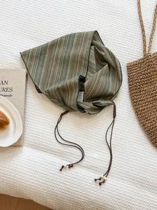 Detailed macro view of a vintage striped triangular scarf with brown string ties