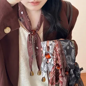 Elegante Retro-Halskette mit Paisleymuster und durchscheinenden Bernsteinharzperlen.