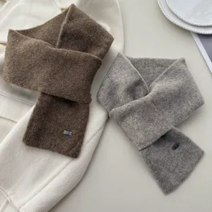 Soft knit crossed scarves in brown and grey with cozy wool-like texture for winter.