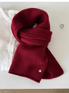 Soft burgundy 100% wool knitted scarf detail with metal tag.
