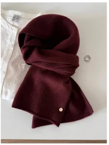 Close-up of premium burgundy 100% wool knitted scarf showing fine texture and metal tag