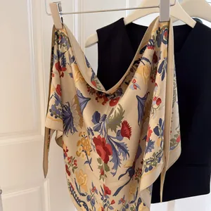 Elegant vintage floral print silk triangle scarf styled with a navy vest on a hanger