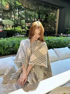 Elegante geruite sjaal poncho voor dames in een luxe buitenomgeving levensstijl