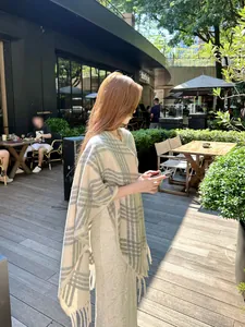 Elegante beige en groene geruite sjaal voor dames in een gezellig café in de buitenlucht