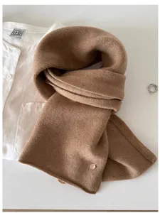 Detailed macro view showing the soft texture of a 100% wool fine knit scarf in camel brown