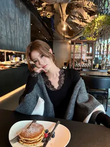 Elegante dames sjaal met kleurblokken gedragen in een stijlvolle cafe setting