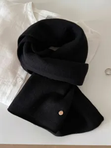 Close-up of a soft 100% wool fine knit scarf in classic black on a white shirt