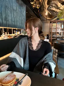 Elegante grijs-witte kleurblok sjaal voor dames in een luxe café-omgeving gestyled.