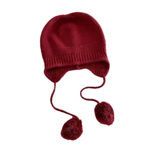 Premium 100% wool knitted beanie featuring earflaps and pom-poms in deep wine red