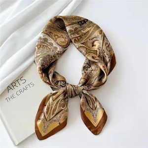 Detailed view of a retro paisley silk scarf featuring elegant brown and gold floral patterns