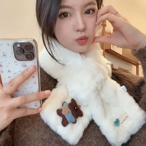 Close-up of a white faux fur scarf featuring a cute bear detail and soft fluffy texture
