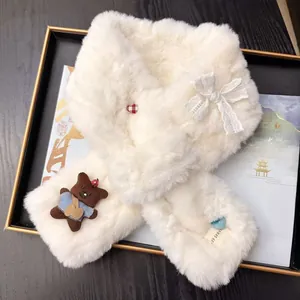 Close-up detail of a white plush winter scarf featuring a cute bear doll and lace bow.