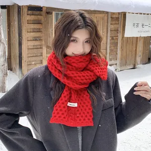 Bufanda roja de punto grueso con patrón de panal lucida por modelo en la nieve
