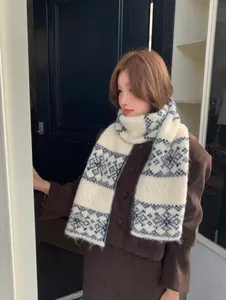 Detail view of a soft snowflake jacquard knitted scarf worn by a model in winter