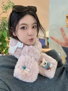 Close-up of pink plush scarf featuring a cute bear patch and white lace bow decoration