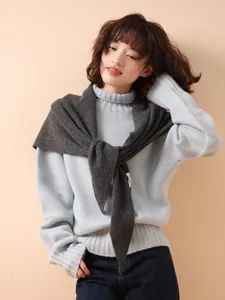 Detail of dark grey 100% wool knit triangle shawl worn over light blue turtleneck sweater