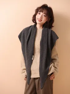 Close-up of a charcoal grey 100% wool knit triangle shawl on a female model.
