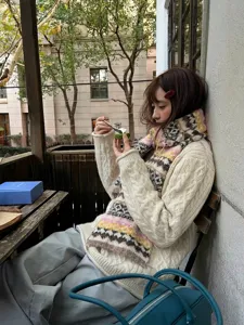 Vrouw met een gezellige retro Fair Isle alpaca wollen sjaal in de winteromgeving