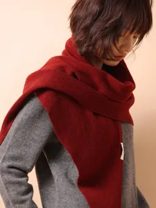 Detail of a red 100% Australian wool knit triangular shawl worn on a fashion model