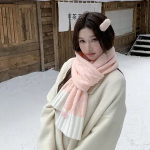Korean style pink and white knitted winter scarf shown in a beautiful snowy outdoor scene