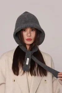 Dettaglio del passamontagna in maglia grigia spessa con sciarpa integrata su modella