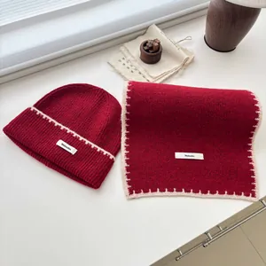 Primo piano di set berretto e sciarpa in maglia rossa con bordo bianco cucito