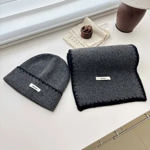 Vista dettagliata di un set berretto e sciarpa in maglia grigio scuro con etichette Mulanduo.