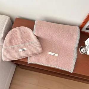 Accogliente set berretto e sciarpa in maglia rosa elegantemente esposto su un tavolo in legno