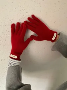 Close-up detail of premium red 100% merino wool knitted gloves for winter warmth