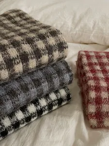 Close-up detail of soft checkered knitted scarves in various warm winter colors