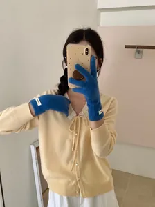 Close-up of stylish blue merino wool knitted gloves worn by a female model for winter