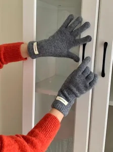 Detail shot of grey 100% wool knitted gloves showing the soft texture and fit on hands.