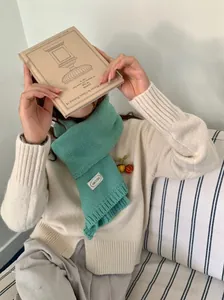 Mintgroene gebreide sjaal met een crème trui voor een gezellige winterlook