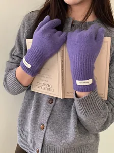 Close-up of soft purple 100% merino wool knitted gloves being worn with a grey cardigan.