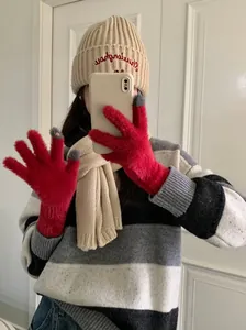 Close-up of a fashion model wearing red coral fleece warm gloves for winter touch screen