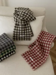 Detailed view of various checkered knit scarves displayed in cozy autumn and winter colors.