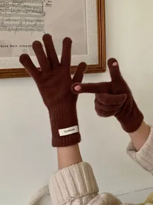 Detailed view of brown 100% wool knitted gloves with functional touchscreen holes.