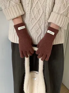 Detailed view of woman wearing warm rust brown 100% wool knit gloves for winter protection