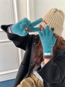 Detail view of blue coral fleece gloves showing touchscreen tips and soft texture