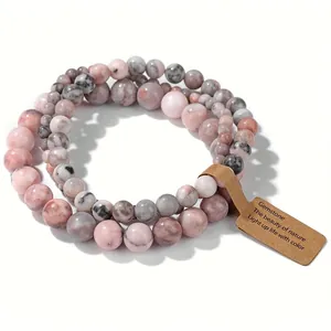 Détail macro de l'ensemble de trois bracelets en perles de pierre rose avec étiquette