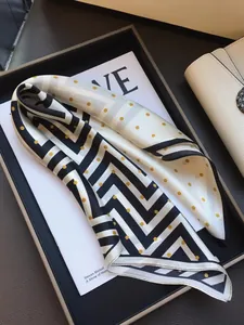 Detail of square silk-like scarf with black zig-zag patterns and yellow polka dots
