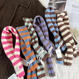 Macro detail of various color striped wool blend knit scarves with brand labels
