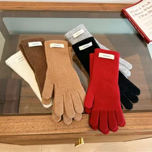 Detail of multiple 100% merino wool knitted gloves in various warm winter colors